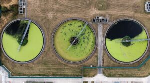 Aerial view above waste water treatment plant with green algae