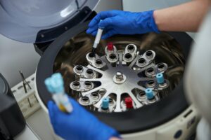 Lab technician using a centrifuge for a biochemical analysis